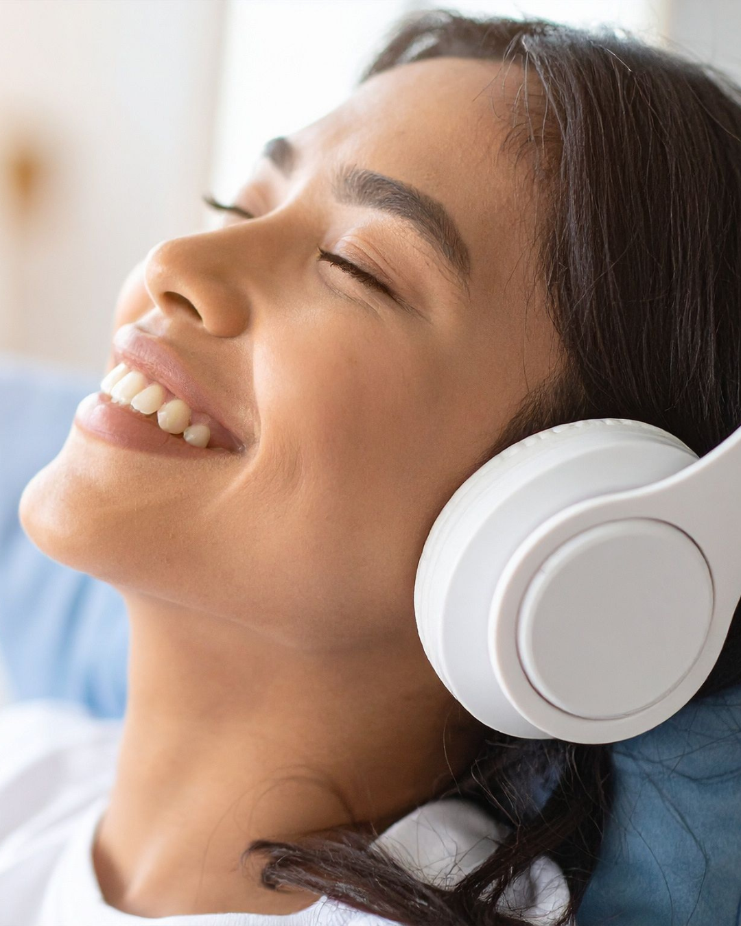 Woman smiling while listening to her custom hypnosis recording from Pao Hypnosis
